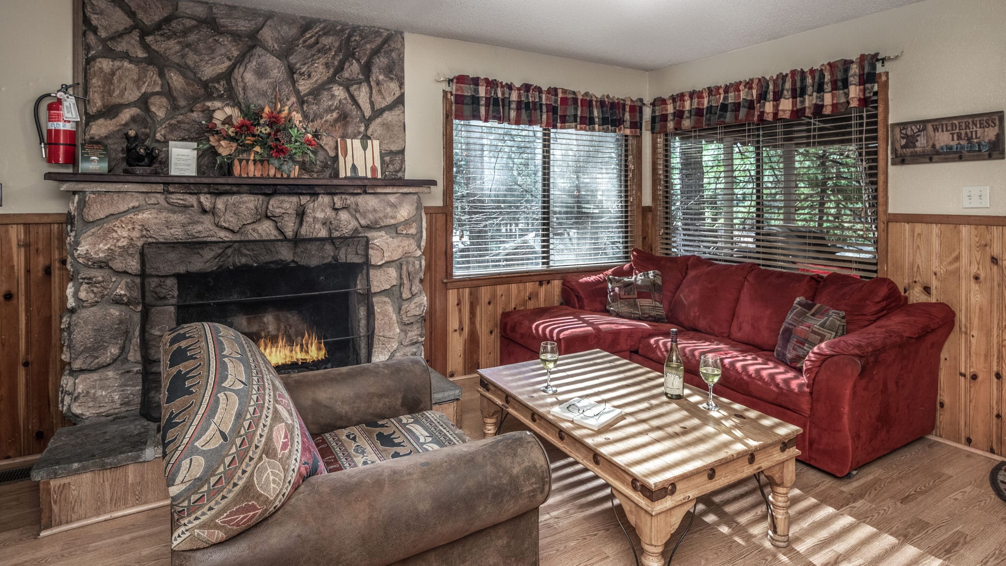 Two couches next to a stone fireplace.